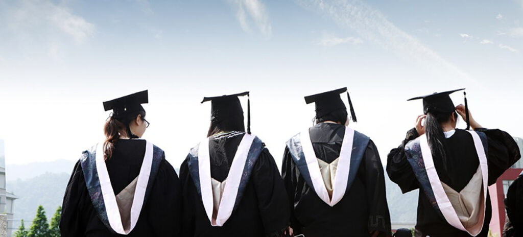 A photo of graduates facing a bluebird sky