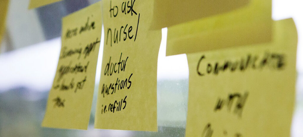 A glass wall covered with various idea-filled sticky notes