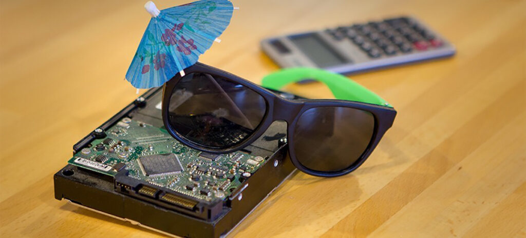 A photo of a hard drive with "disguised" with a drink umbrella and sunglasses