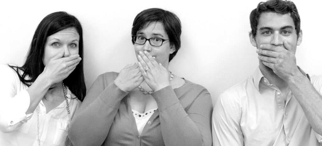 A photo of three people covering their mouths