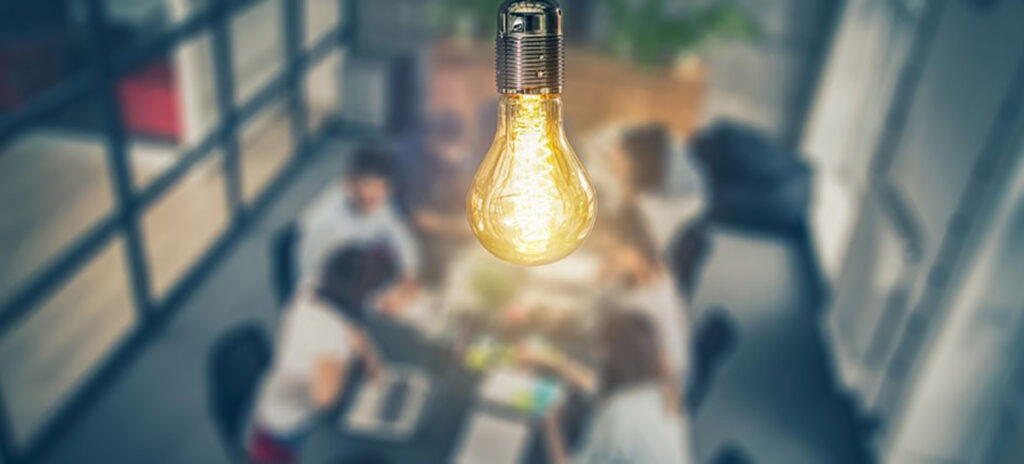 A glowing lightbulb above a workshop in progress