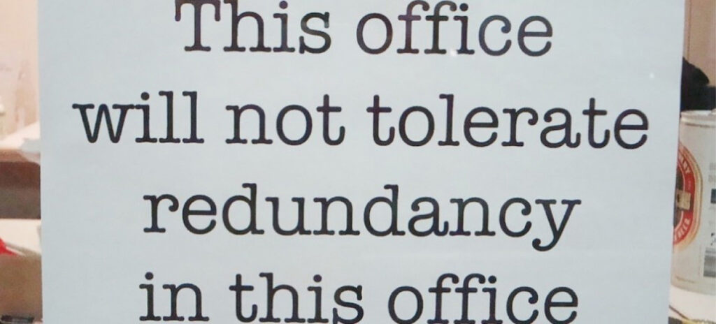 Sign with the text "This office will not tolerate redundancy in this office"