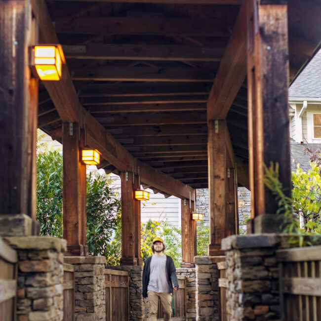 A male student walking a covered path at Warren Wilson College