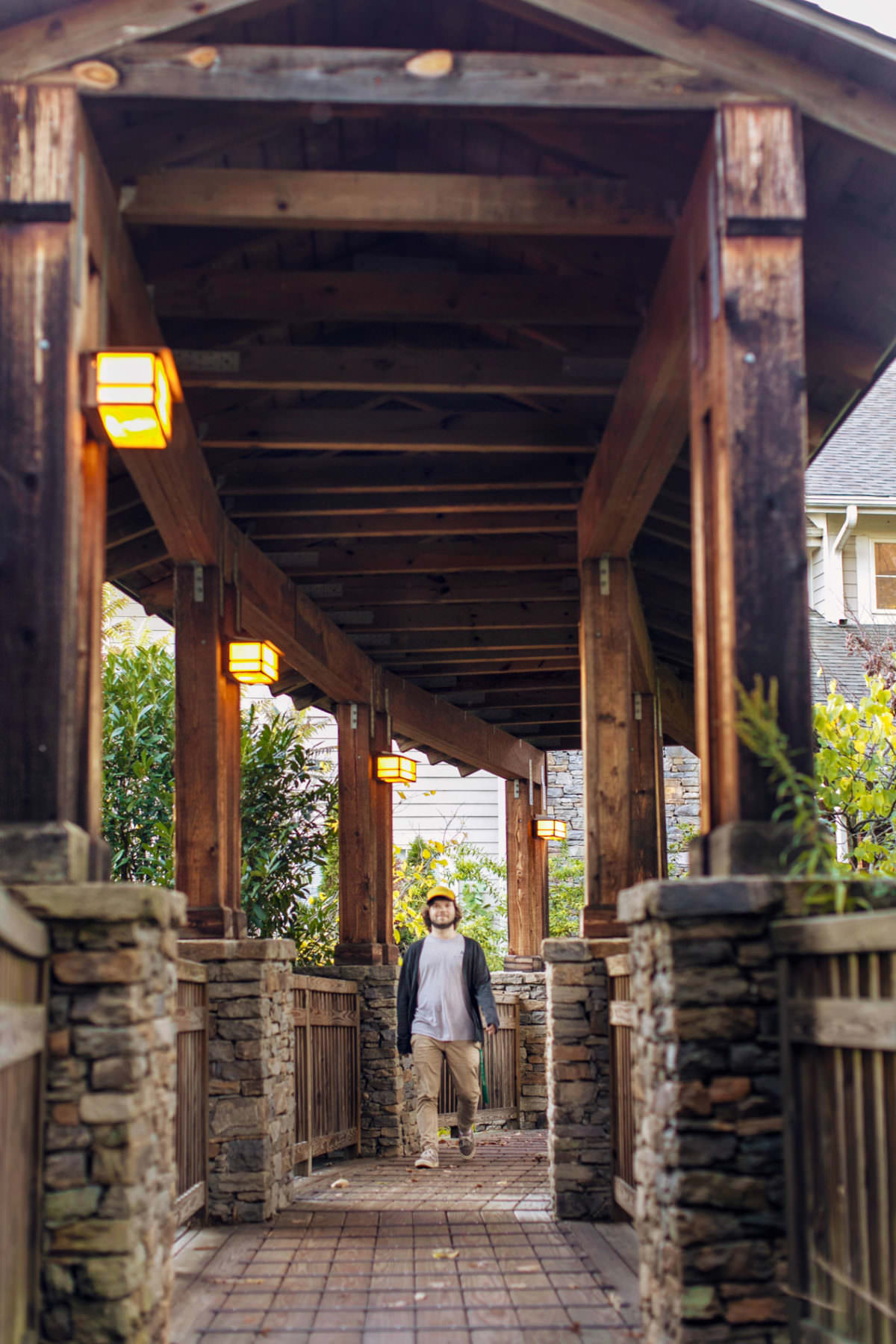 A male student walking a covered path at Warren Wilson College