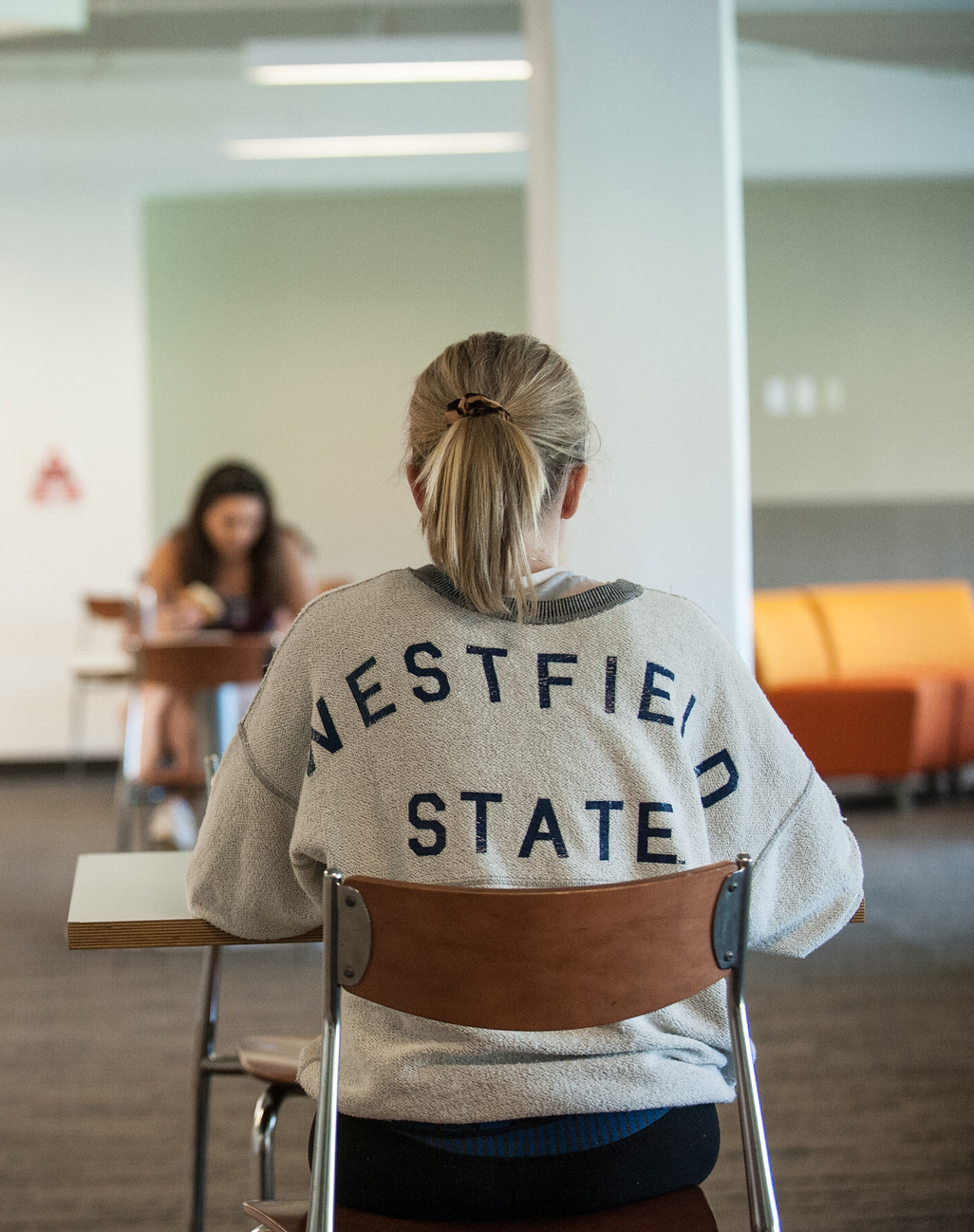A female student studying and wearing a Westfield State sweatshirt
