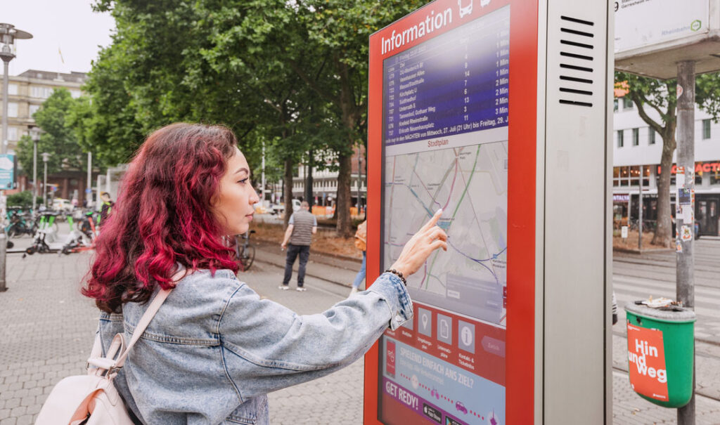 Woman looking at public transit map on a digital sign