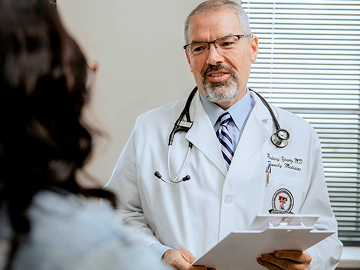 A Texas Tech Physicians healthcare provider talks to a patient in an exam room