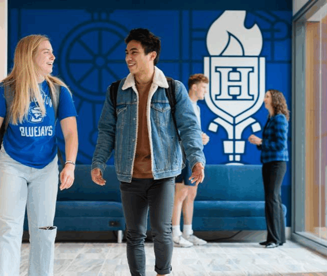 Two creighton students walking and talking on campus