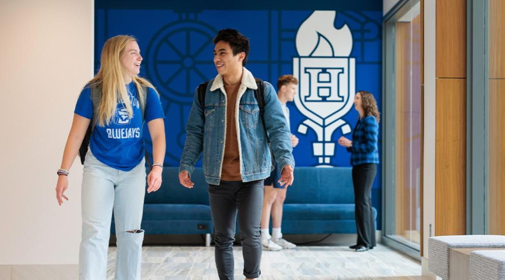 Two creighton students walking and talking on campus