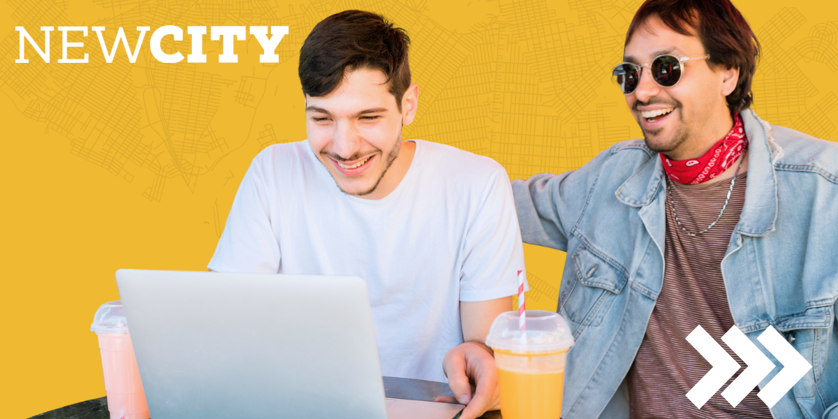Two young men look at a laptop screen